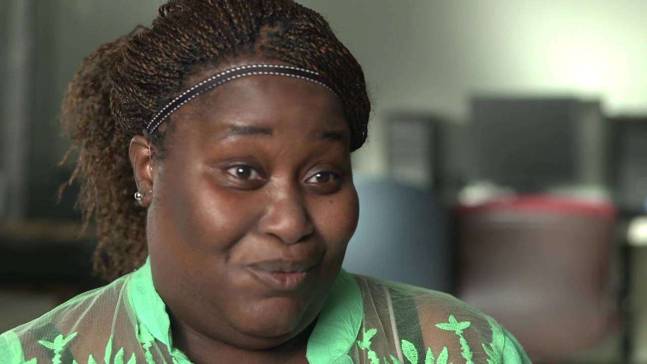 A smiling woman being interviewed in an office